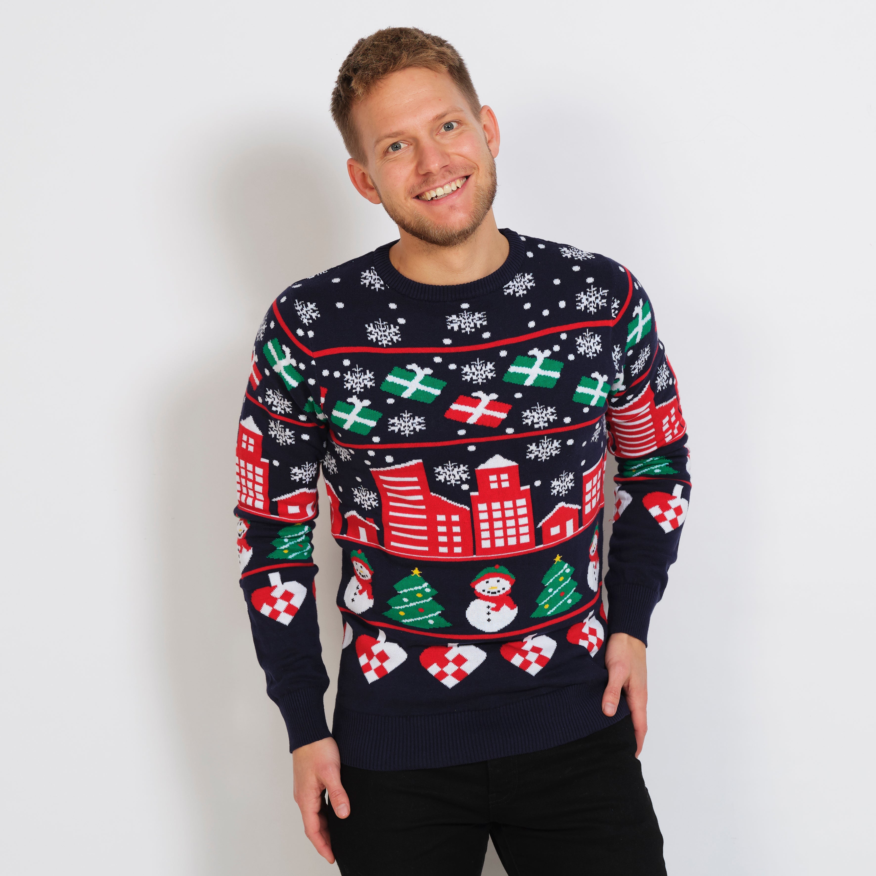 En smilende mann iført julegenser med snøfnugg og gaver.